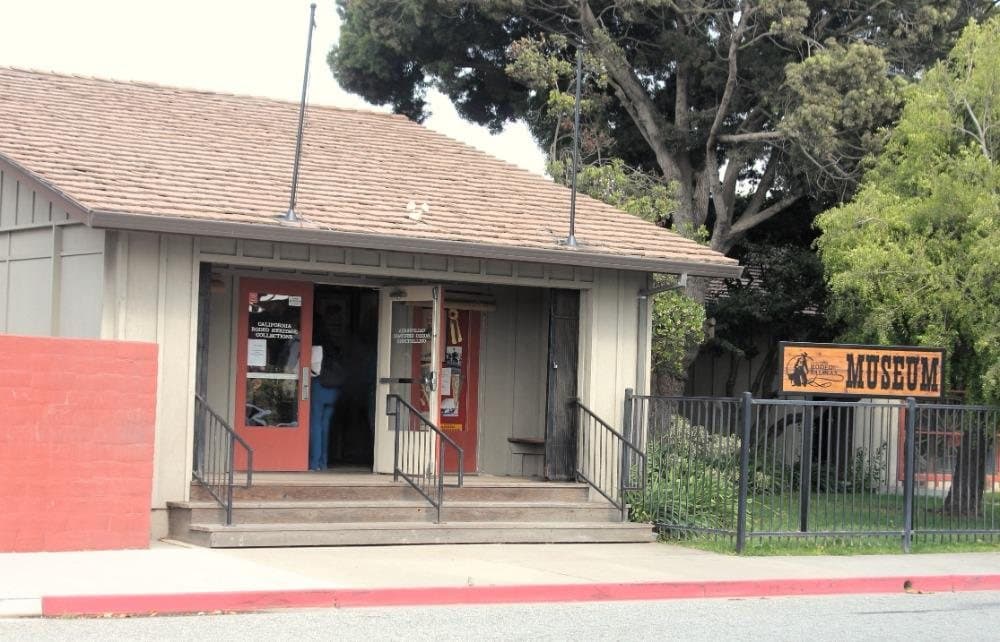 The California Rodeo Museum, a single-storey building with a tiled roof and an open front door, beside a sign reading Museum.